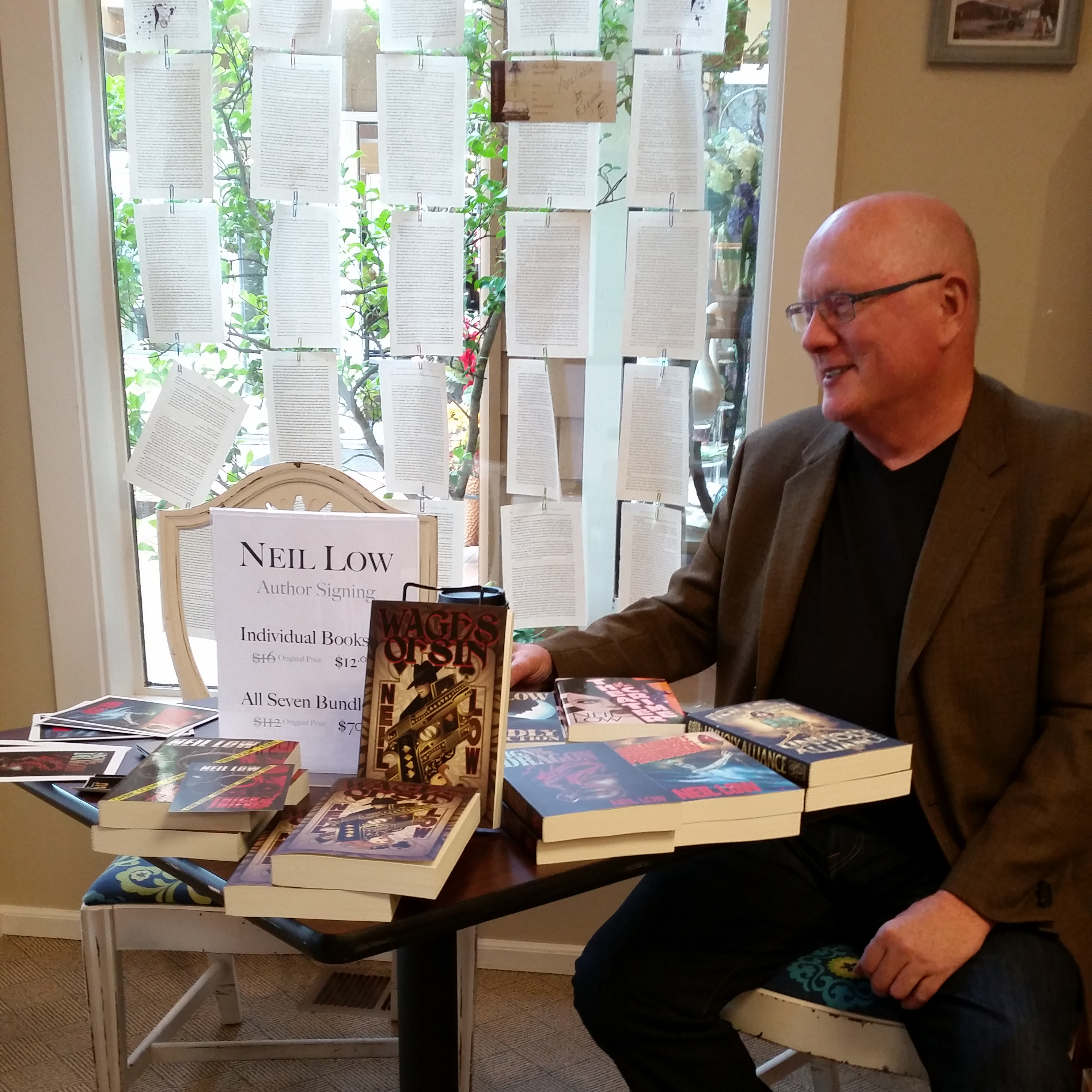 Author Neil Low With His Novels On The Table